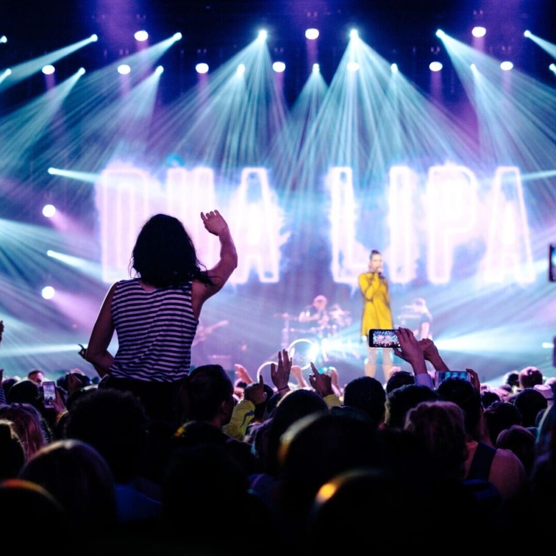 A crowd of people at an event with lights.